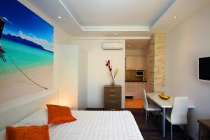 a bedroom with a bed and a table and a kitchen at Villa Principessa Podstrana in Podstrana