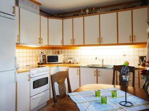 a kitchen with white cabinets and a wooden table at 5 person holiday home in Bullaren-By Traum in Bullaren