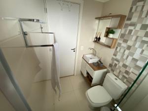 a small bathroom with a toilet and a sink at 2 suítes - 7 lugares, sua família prox Catedral de Pedra in Canela