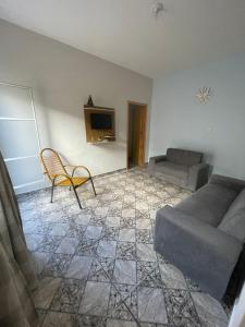 un salon avec un canapé et une chaise dans l'établissement Casa 7 min da Basilica, à Aparecida