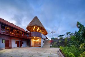 a building with a pointed roof with a patio at Kintamani Breeze in Kubupenlokan
