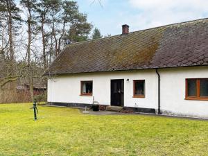 a white house with a black roof and a yard at 5 person holiday home in LÖDDEKÖPINGE in Löddeköpinge