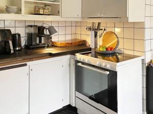 a kitchen with white cabinets and a stove top oven at 5 person holiday home in LÖDDEKÖPINGE in Löddeköpinge +22 photos