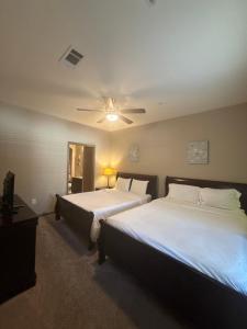 une chambre avec deux lits et un ventilateur de plafond dans l'établissement Resort Style Apartment/Home - The Woodlands, à The Woodlands 75 autres photos