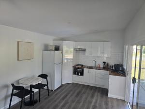 MataveraにあるT&T Retreatの白い家電製品とテーブルと椅子を備えたキッチン