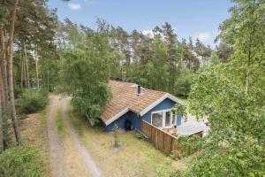 a small blue house in the middle of a forest at 2608-Nexo-Munkegardsskoven-17 in Neksø