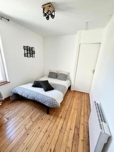 a bedroom with two beds and a wooden floor at Chez Gabin in Carentan