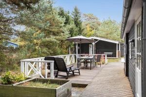 a deck with a table and chairs and an umbrella at 3501-Nexo-Granvej-6 in Neksø