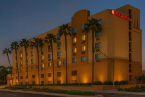 un hotel con palmeras frente a un edificio en Ramada by Wyndham Hawthorne/LAX, en Hawthorne