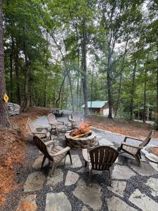 a group of chairs around a fire pit in the woods at Hillside Hideaway Cabin in Blairsville