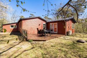 a small red house with a wooden deck at 3712-Nexo-Aastien-8 in Neksø