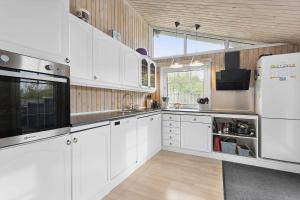 a kitchen with white cabinets and a white refrigerator at HA286-Saeby-Nellemannsvej-12 in Sæby