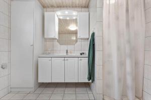 a white bathroom with a sink and a shower at HA286-Saeby-Nellemannsvej-12 in Sæby +10 photos