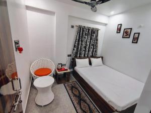 a small bedroom with a bed and a chair at Magadh Homestay in Patna