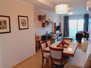 a dining room and living room with a table and chairs at 2 suítes - 7 lugares, sua família prox Catedral de Pedra in Canela