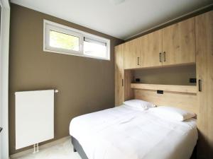 ein Schlafzimmer mit einem großen weißen Bett und einem Fenster in der Unterkunft Modern Lakeview Cottage in Veluwe in Hoenderloo + 30 Fotos