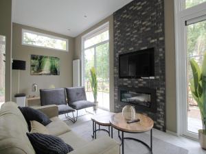 ein Wohnzimmer mit Couch und Kamin in der Unterkunft Modern Lakeview Cottage in Veluwe in Hoenderloo