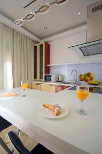 a kitchen with two glasses of orange juice and food on a counter at Villa Principessa Podstrana in Podstrana