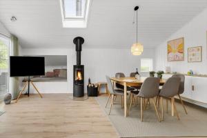 a dining room with a fireplace and a table and chairs at OH551-Hadsund-Ved-Fruerlund-35 in Hadsund