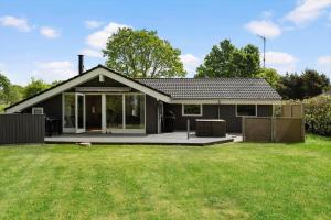a small house with a patio and a yard at OH551-Hadsund-Ved-Fruerlund-35 in Hadsund