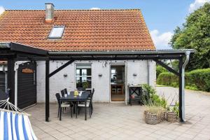 a patio with a table and chairs and a house at FY378-Hesselager-Bellisvej-37 in Hesselager