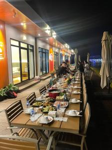 un lungo tavolo con piatti di cibo sopra di Romantic Resort MuangFuang a Muang Fuang