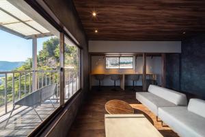 a living room with a couch and a balcony at the Terrace 長浜 in Kure