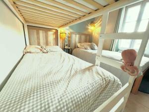 una camera con due letti a castello e un gatto sdraiato sul letto di Maison confortable 4 pers. avec jardin fermé à L'Épine, proche plage - FR-1-823-27 a LʼÉpine