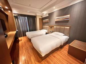 a hotel room with two beds and a television at Home Inn Paibaiyun Hotel Beijing Changying Subway Station Chaoyang Hospital East Branch in Beijing