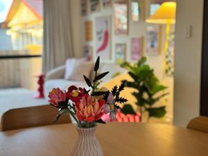 a vase filled with flowers sitting on a table at Colour Burst Townhouse in Christchurch +2 photos