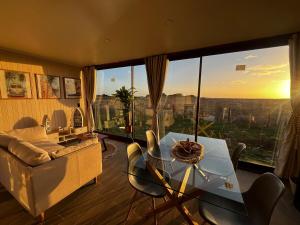 a living room with a table and chairs and a large window at Casa del Sol in Cobquecura