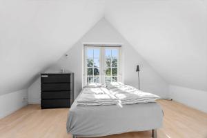 a white bedroom with a bed and a window at FY285-Faaborg-Egsgyden-35 in Fåborg