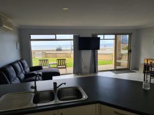 a kitchen with a sink and a view of the beach at Tumby Bay Hotel Seafront Apartments in Tumby Bay