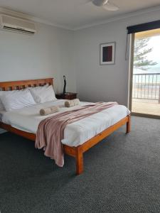 a large bed in a room with a window at Tumby Bay Hotel Seafront Apartments in Tumby Bay
