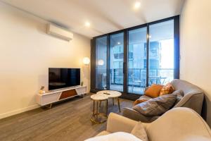 un salon avec un canapé et une télévision dans l'établissement The Valley Edit | Designer Stay, Carpark + Pool, à Brisbane