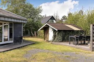 a house with a table and chairs on a deck at FY144-Middelfart-Vegavej-40 in Middelfart