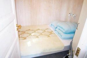 a small room with a bed and blue towels at FY320-Nyborg-Strandskovvej-9 in Nyborg