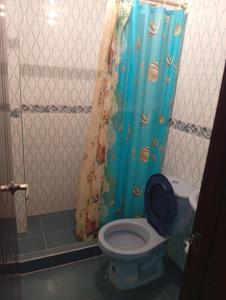 a bathroom with a toilet with a shower curtain at Hostal ML las tres B in El Cocuy