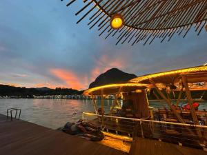 una barca seduta sull'acqua al molo di Romantic Resort MuangFuang a Muang Fuang