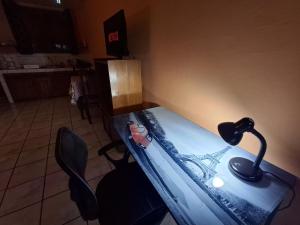 mesa con lámpara y 2 sillas en una habitación en Apartamentos Quepos Malichita Studio, en Quepos