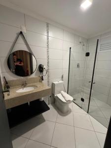 une salle de bain avec toilettes, lavabo et miroir dans l'établissement Ap Barretos Park - O quarto mais luxuoso do hotel, à Barretos