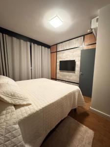 une chambre avec un grand lit et une télévision dans l'établissement Ap Barretos Park - O quarto mais luxuoso do hotel, à Barretos