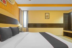 a bedroom with a large white bed with black pillows at MGR Residency in Puducherry +6 photos