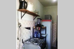 a small kitchen with a stove and a refrigerator at Minha Casa, Seu Hostel in Recife
