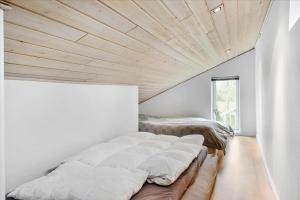 a bedroom with two beds and a wooden ceiling at LF15198-Hojslev-Bronzehojen-7 in Højslev