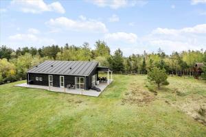 a black cabin in the middle of a field at LF15198-Hojslev-Bronzehojen-7 in Højslev