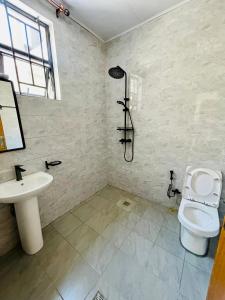 a bathroom with a toilet and a sink at Iwabo Apartments Kigali Airport Kanombe in Kigali +43 photos