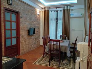 a dining room with a table and chairs and a tv at Mekong Palm House in Can Tho