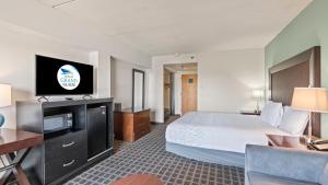 a hotel room with a bed and a flat screen tv at Inn at Grand Glaize in Osage Beach