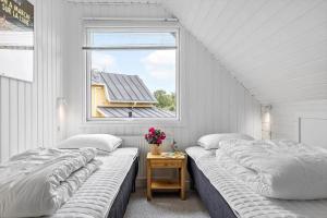 two beds in a room with a window at LF14127-Roslev-Kybehuse-127 in Roslev